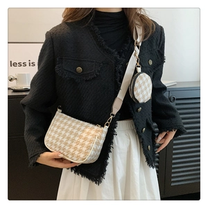 Detail of houndstooth crossbody set featuring a round coin pouch and wide strap