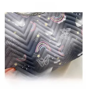 Detail of the V-shaped quilted fabric with colorful star and rainbow prints on dark gray base