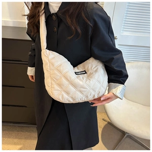 Gros plan du sac fourre-tout matelassé beige avec étiquette et bandoulière large
