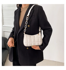 Nahaufnahme der weißen gesteppten Filztasche mit Acrylkette und Lederriemendetail