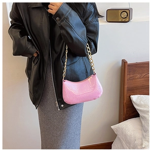 Dettaglio borsa a spalla rosa con paillettes e catena dorata per un look trendy