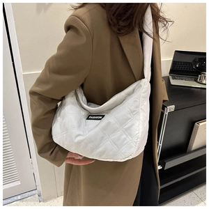 Détail du sac matelassé blanc avec coutures en losanges et étiquette fashion
