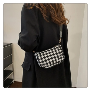 Detail of houndstooth crossbody bag with adjustable wide strap shown in a lifestyle view