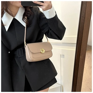 Détail du sac beige avec boucle en métal doré et bandoulière fine au style minimaliste