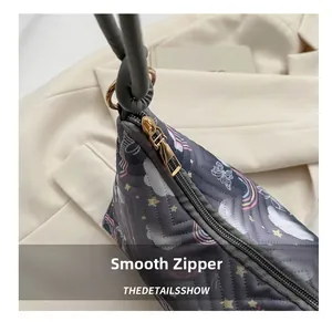 Detail of smooth gold zipper and quilted fabric with rainbow and star patterns