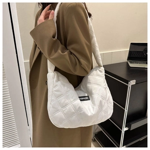Détail latéral d'un sac hobo matelassé blanc avec étiquette de mode sur un mannequin