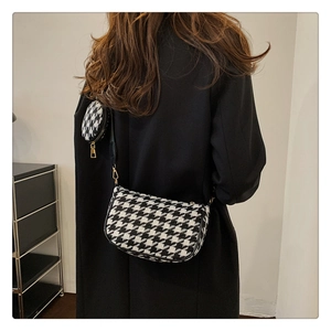 Detail of houndstooth tweed saddle bag with a mini round coin purse and gold hardware