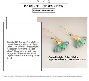 Detail of butterfly earring with 18K gold plating, resin wings and small rhinestones