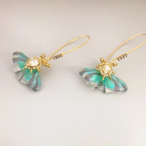 Elegant gold-plated long hook earrings featuring translucent teal butterfly pendants