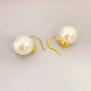 Elegant gold-plated hook earrings featuring large white round pearls with minimalist design