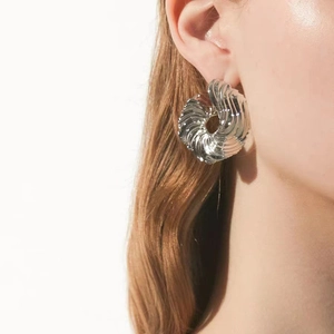 Chic silver-toned irregular spiral textured hoop earrings worn by a female model
