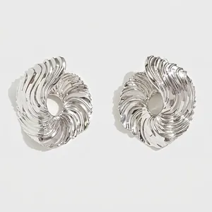 Modern silver earrings with textured spiral swirl and artistic irregular wavy metal finish
