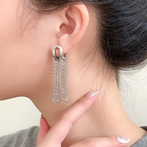 Detail of silver chain fringe earrings on model featuring elegant long tassel design