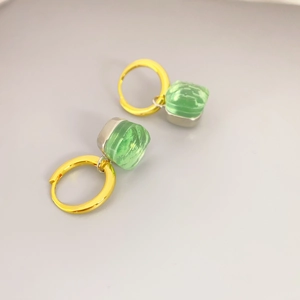 Elegante goldene Creolen mit quadratischen grünen Kristallanhängern im 45-Grad-Winkel