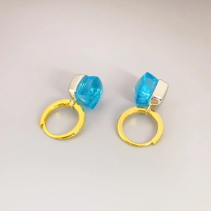 Detailansicht goldener Creolen mit facettierten himmelblauen Kristallanhängern