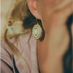Boucles d'oreilles ovales turquoise vintage avec texture tressée dorée sur modèle