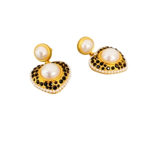 Fashionable gold heart earrings featuring large pearls and black zircon accents on white background