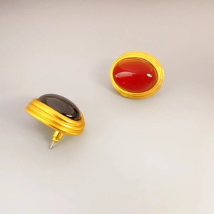 Vintage oval gold earrings with red and black agate stones in a textured spiral design