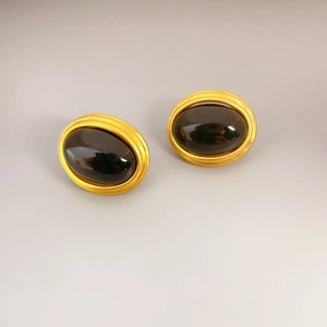 Vintage oval gold earrings with spiral texture and dark agate inlay in minimalist style