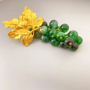 Gold-plated grape leaf earrings with vibrant green chalcedony beads in a naturalistic style
