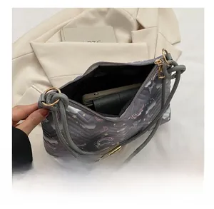 Detail view of the spacious interior of a quilted grey shoulder bag with cartoon prints