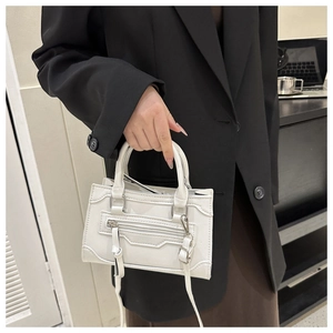 Detail of white PU leather crossbody bag with iconic horizontal zipper and stitching