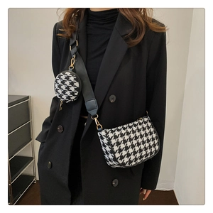 Fashionable houndstooth crossbody bag with wide strap and mini round pendant detail