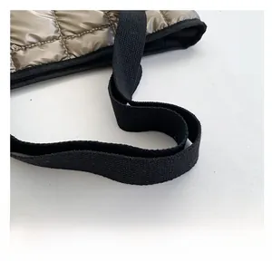 Detailed close-up of metallic bronze quilted tote bag featuring durable black canvas handles