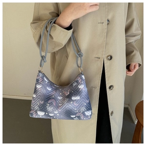 Close-up of a nylon shoulder bag with cartoon prints and knotted strap details