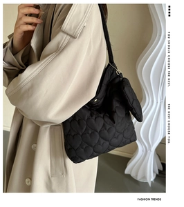 Détail du sac cabas matelassé noir avec motifs cœurs en 3D et mini pochette cœur