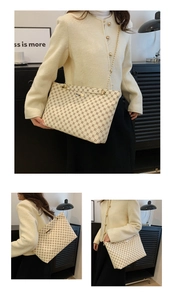 Detail of beige tote bag with clover patterns and elegant gold chain strap accents