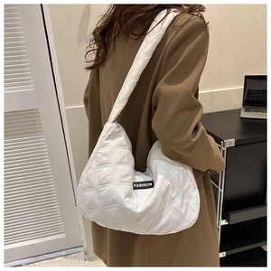 Détail d'un sac cabas matelassé blanc avec étiquette FASHION noire et motif à losanges