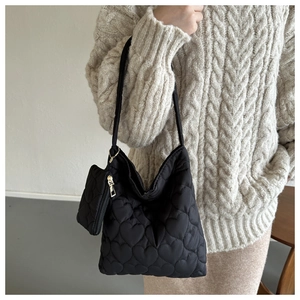 Détail du sac bandoulière matelassé cœur noir avec un petit porte-monnaie assorti