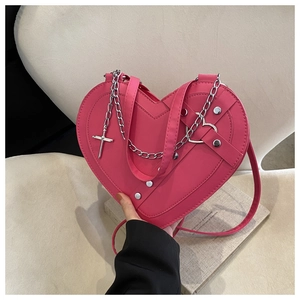 Detailed view of hot pink heart-shaped bag with silver chain and cross charm