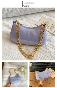 Dettaglio della borsa a spalla viola glitterata con catena dorata e cerniera lampo