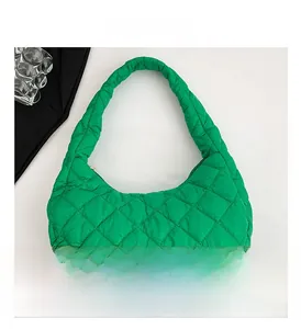 Close-up of green quilted nylon fabric and soft puffy texture of the crossbody bag