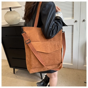 Close-up of caramel corduroy tote bag showing textured fabric and front pocket detail