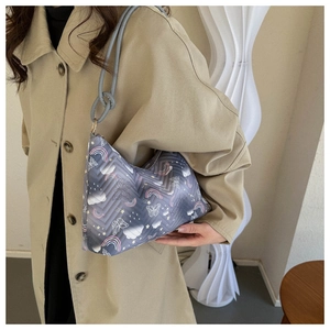 Detailed side view of cute quilted light blue shoulder bag with cartoon prints on model