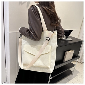 Corduroy tote bag detail showing large capacity and adjustable strap on model
