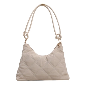 Minimalist beige quilted shoulder bag with knotted straps and elegant gold-tone hardware
