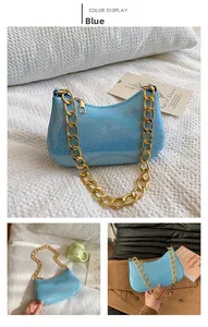 Dettaglio borsa a mezzaluna blu glitterata con tracolla a catena dorata lucida