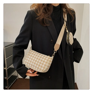 Detail of houndstooth underarm bag set with round coin purse and beige nylon strap