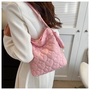 Détails du sac à bandoulière rose matelassé avec motifs de cœur et zips dorés