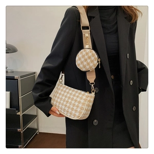 Detail of houndstooth crossbody bag with matching round coin purse on shoulder strap