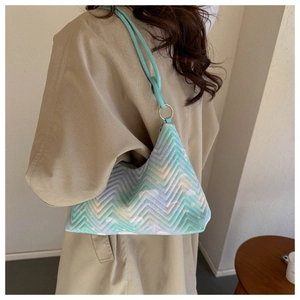 Detail of mint green nylon shoulder bag with V-shaped quilting and golden rings