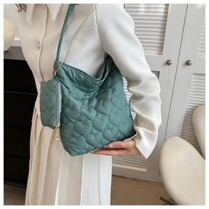 Détail du sac cabas matelassé vert foncé avec motif de cœurs et petite pochette assortie