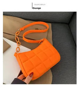 Detail einer orangefarbenen gesteppten Filz-Schultertasche mit modischer Kette