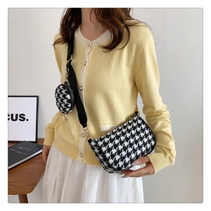 Close-up of houndstooth crossbody bag with an adjustable strap and small coin purse