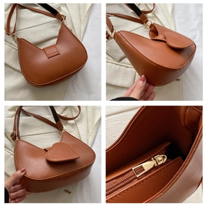 Detail view of brown faux leather shoulder bag featuring heart-shaped LOVE embossing