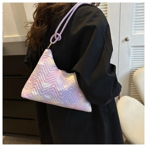 Detail of purple quilted triangular shoulder bag with butterfly pattern worn on black coat